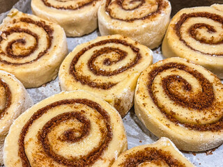 Homemade uncooked cinnamon rolls in a pan for proofing