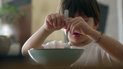 Spaghetti delight - Little boy attempting to spin fork while eating pasta food during mealtime....