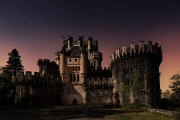 Night view of the main façade of Butron Castle, in Gatica, Bizkaia, illuminated by moonlight under...