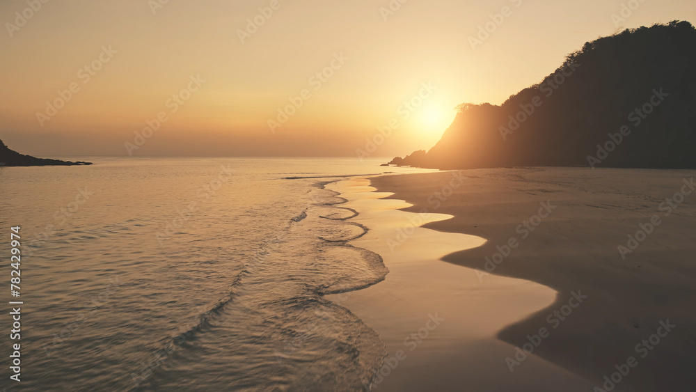 Wall mural Slow motion sunset seascape at mountain island aerial. Tropic nobody nature landscape at summer sun set light evening. Ocean waves at sand beach. Cinematic El Nido Island, Philippines, Asia