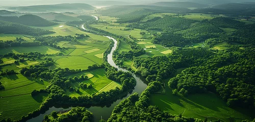Fotobehang A stunning aerial picture of a verdant valley, bathed in the gentle glow of the summer sun, with patchwork fields, verdant woodlands, and flowing rivers stretching towards the horizon. © Rai