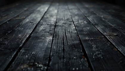 Close up of parallel hardwood planks on dark flooring in a dimly lit room. Black background