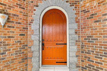 Aged Classic Burnt Orange Wooden Door with Stone Archway, Brick Exterior Facade