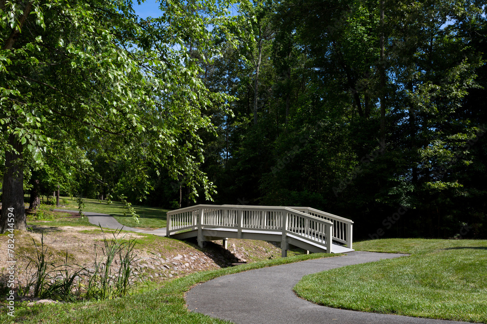 Wall mural Tranquil Park Bridge Over a Small Creek, Paved Walking Bath