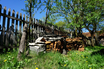 weathered roofing tiles on old farm, peaceful stil life of fence in sunshine on green grass, farm in Boljanic, Doboj, Republic of Srpska, Bosnia and Herzegovina