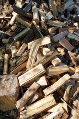 A pile of chopped firewood logs ready for the winter. Cut logs fire wood. Hardwood, wood and lumber industry. Heating season, winter season. Renewable