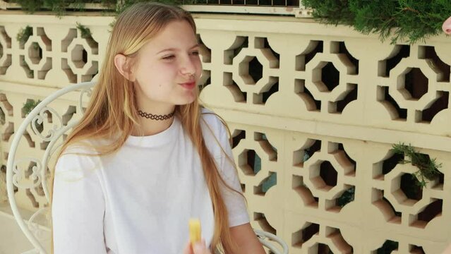Mom lovingly feeds her teenage daughter delicious churos in the fresh air, enjoying warm day and pleasant conversation. Traditional Spanish pastry churos