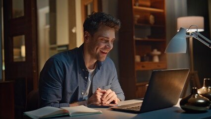 Laughing specialist enjoying videocall by laptop sitting apartment alone closeup