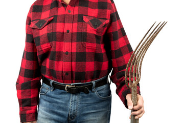 An unidentifiable farm worker in a red and black plaid shirt holds a manure pitch fork isolated on...