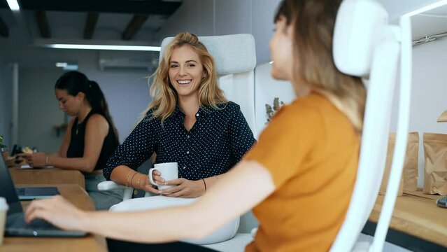 Video of  beautiful young businesswomen talking while having a break of work on coworking space