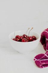 Cherries on a bowl, on white background. Minimalist composition.