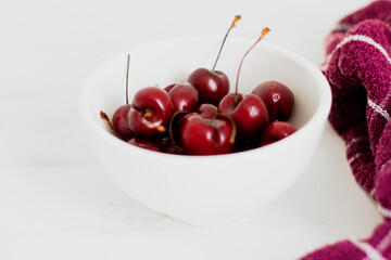 Cherries on a bowl, on white background. Minimalist composition.