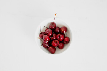 Cherries on a bowl, on white background. Minimalist composition.
