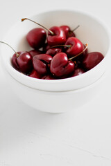 Cherries on a bowl, on white background. Minimalist composition.