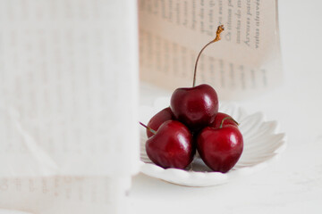 Cherries on a bowl, on white background. Minimalist composition.