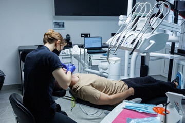 Modern stomatological office. An orthodontist installs braces. Treatment of teeth of a person with...