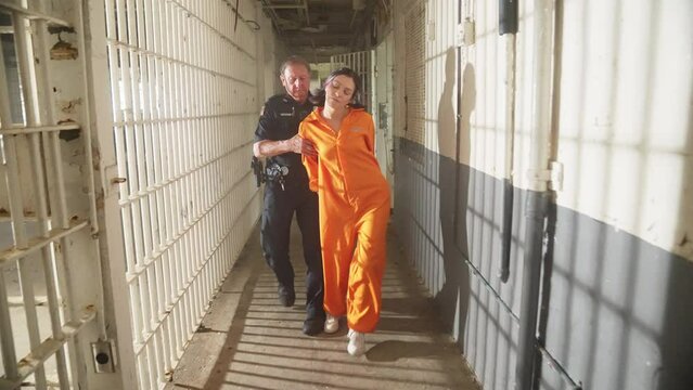 Female Woman Prisoner in Orange Jumpsuit Jail Prison with Police Officer