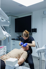 Modern stomatological office. An orthodontist installs braces. Treatment of teeth of a person with...