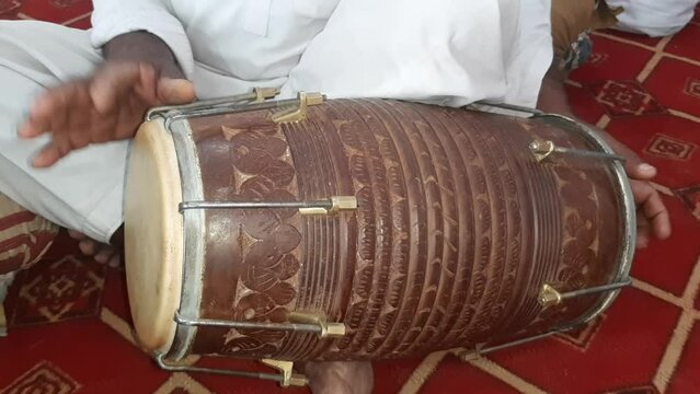 A Man Playing Dholak. Closeup shot of hands of a Man playing Dholak. Traditional world. Folk instrument. Wood Instrument. Pakistani man playing Dholak in the house. Beautiful 4K Footage.