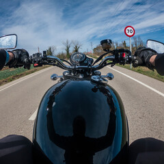 Riding a black motorbike on an asphalt road rider point of view