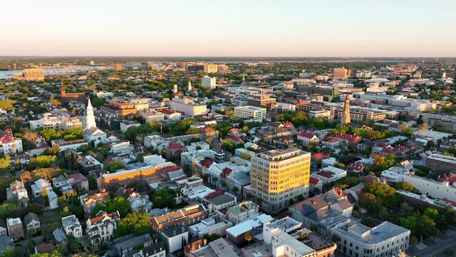 Sunrise over Downtown Charleston, SC, with historic district aerial view, highlighting vibrant rooftops and streets.