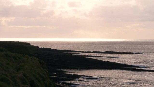 A sunset along the Atlantic Coast, showing an orange sky on an overcast day.  Mullaghmore, Co. Sligo, Ireland.