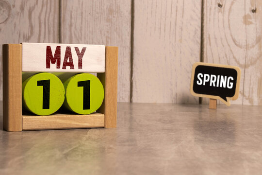 11 Mai on wooden grey cubes. Calendar cube date 11 May. Concept of date.