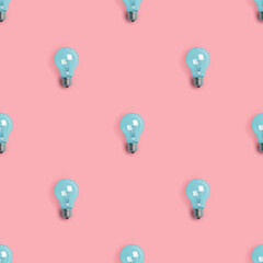 Blue painted lightbulbs on a trendy pink background. Light bulb seamless pattern with shadow - flat lay. Concept of idea, creativity, brainstorming and innovation.