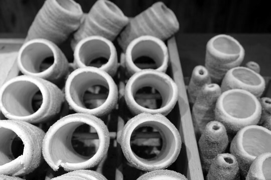 Baumstrietzel oder Trdelnik aus Hefeteig auf Holzst&ouml;cken &uuml;ber dem Feuer im Ofen gebacken am Wenzelsplatz in der Neustadt von Prag an der Moldau in Tschechien in neorealistischem Schwarzwei&szlig;