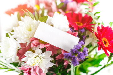 beautiful bright colorful flower bouquet with paper blank white gift card, place for text, sun ray,...