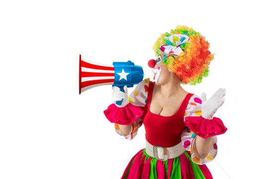 Funny female clown shouting with loudspeaker. Woman entertainer as colorful Joker, suit and wig, clown whiteface makeup. Trickster, jester, pantomime, mime, and a professional actor at events