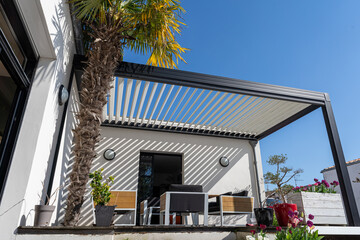 eco friendly bioclimatic aluminum pergola shade structure surrounded by landscaping - obrazy, fototapety, plakaty