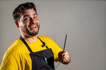 Carnicero feliz afilando su cuchillo mientras sonríe a cámara. Fotografía con Copy Space	
