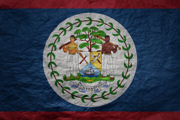 Fototapeta premium big national flag of belize on a grunge old paper texture background