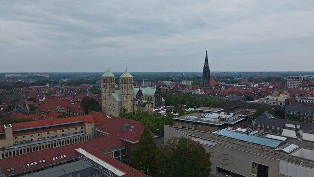 An aerial drone shot of St. Paulus Dom, also known as M&uuml;nster Cathedral, on Domplatz in M&uuml;nster on a sunny day. It is a central and culturally significant area of central M&uuml;nster, Germany. Busy Market