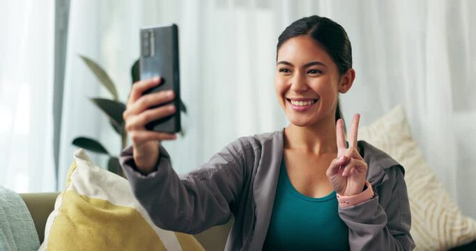 Woman, selfie and smile influencer for picture, blowing kiss and peace sign for social media post. Online, genz and creative content creator on sofa in home lounge, photo and vlog or female person