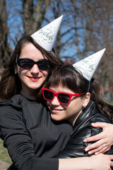 Portrait of a two young women in sunglasses and hats for a birthday party	