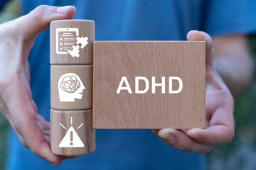 Man holding wooden blocks sees abbreviation: ADHD. Attention Deficit Hyperactivity Disorder ( ADHD ). ADHD syndrome, mental health, psychology concept.