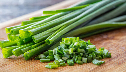 Obraz premium Allium schoenoprasum, popularly known as chives, chives or chives, in Portugal, is a plant originally from Europe. Close up, chopped on wooden board.