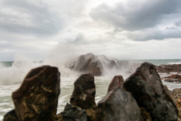 Waves hitting a sea rock with great force.
