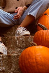 person with no face being sitted on stairs with orange pumpkins halloween celebration  on the steps
