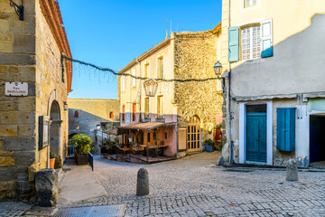 A picturesque street and alley of shops and sidewalk cafes in the La Cite' medieval old town inside the castle at Carcassonne, France. - Powered by Adobe