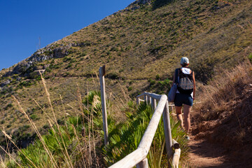 Tourist on a trail in Zingaro natural reserve near Scopello. Sicily Island