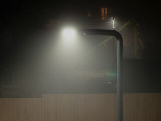 Night city with fog near light. Foggy street in the evening