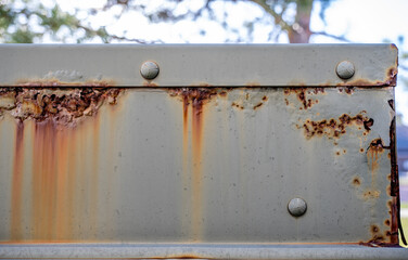 Rusted and peeling paint on an electrical transformer exposed to the elements. 