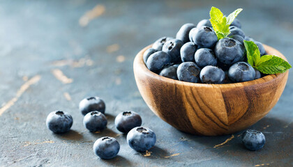 fresh blueberries in a wooden bowl on dark background, selective focus