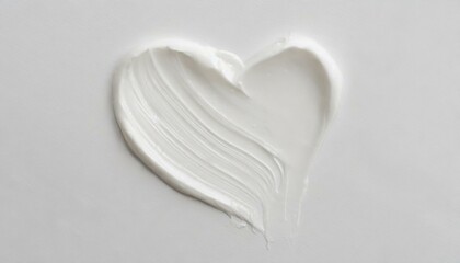 White beauty skincare cream swipe smear in heart shape on white Background. Cosmetics makeup smudge swatches. Top view