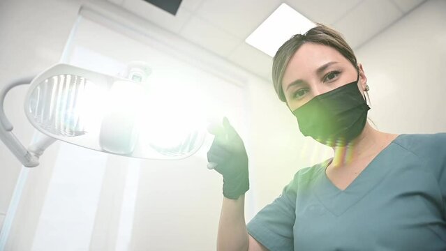 The dentist is preparing to receive a patient. The dentist directs the light towards the patient. Dental treatment in a dental clinic. 