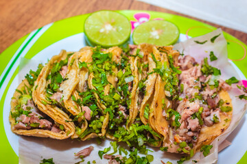 Suadero tacos with cilantro on a plate with lemons, typical Mexican food