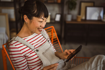Naklejka premium Japanese woman use credit card mobile phone online shopping at home